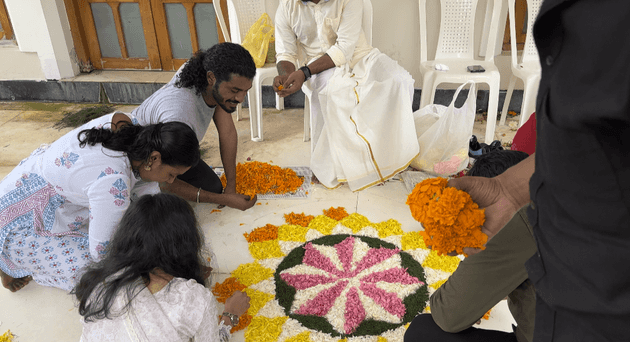 Edstem Technologies team creating beautiful traditional Pookalam design during Onam celebration at company event