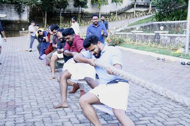 Edstem Technologies employees participating in team building tug-of-war competition during Onam office celebration